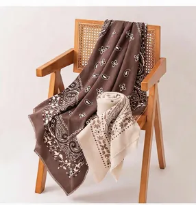 Detailansicht eines Retro-Wollmischschals mit Paisley-Muster auf einem Stuhl