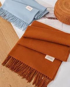 Detailaufnahme weicher einfarbiger Schals mit eleganten Quasten und Day April-Labels