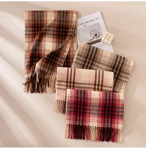 Macro view of several colorful plaid scarves with tassels on a minimalist background