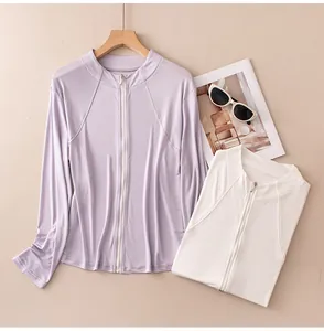 Detail view of slim-fit silk sun protection jackets with zip-up collars in purple and white.