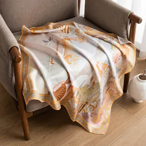 Elegant 16 momme twill silk scarf with traditional landscape print draped on a chair.