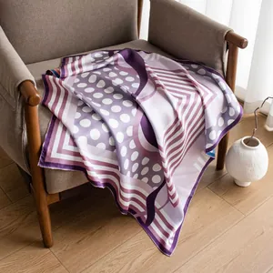 Elegant 16 momme mulberry silk scarf with purple and white geometric patterns on a chair