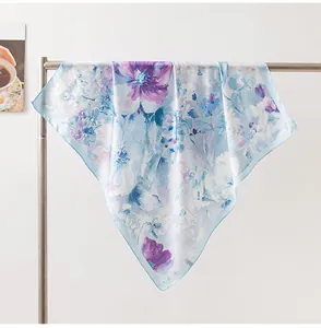 Close-up of a lightweight silk scarf with elegant blue and purple floral patterns