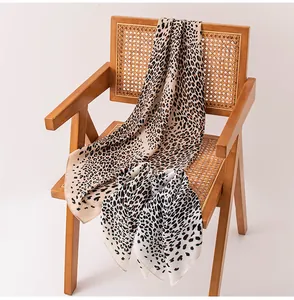 Dettaglio di un elegante foulard in seta leopardato su una sedia vintage