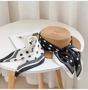 Stylish black and white polka dot silk scarf paired with a classic woven straw boater hat