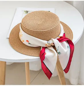 Primo piano di un foulard di seta a fiori su un cappello di paglia