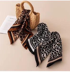 Foulard in seta leopardati su una borsa di paglia con sfondo di una rivista
