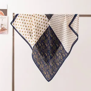 Détail d'un foulard en soie à motifs paisley et pois sur un support élégant