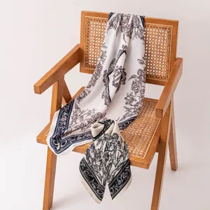 Elegante foulard quadrato in seta con stampa floreale vintage su una sedia di legno
