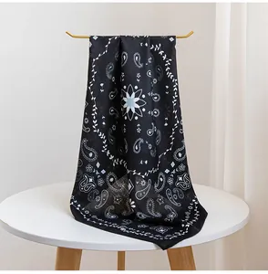 Détail d'un bandana noir vintage avec motifs paisley et fleurs délicates