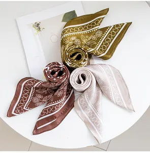 Drie elegante bedrukte zijde-gevoel vierkante sjaals in olijf, bruin en beige kleuren.