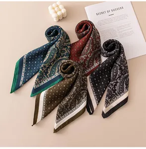 Dettaglio di eleganti foulard di seta quadrati con stampe vintage paisley e pois
