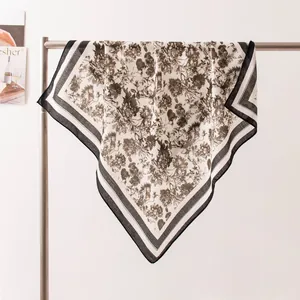 Élégant foulard carré en soie avec un imprimé floral vintage sur un support métal