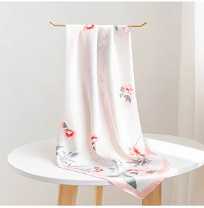 Vista dettagliata che mostra l'elegante stampa floreale e la consistenza liscia dello scialle