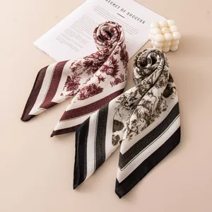 Gros plan détaillé de foulards en soie à motifs floraux rétro en bordeaux et noir