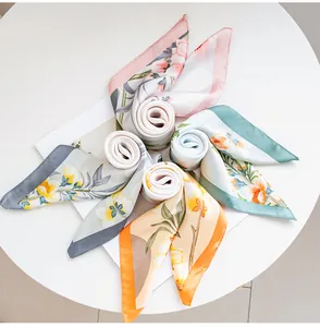 Vista dettagliata di foulard in finta seta con stampa floreale in vari colori