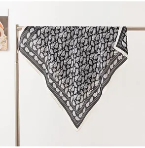 Dettaglio di un foulard leggero con stampa paisley appeso a un espositore