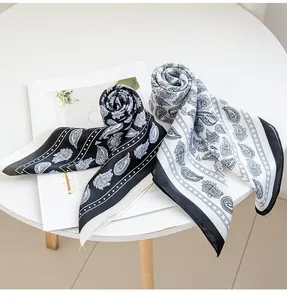 Dettaglio di due eleganti sciarpe in finta seta con stampa paisley in nero e bianco