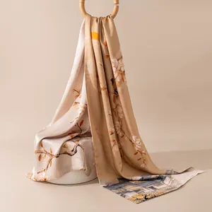 Detail of high-end silk scarf showing elegant floral prints and smooth satin texture.