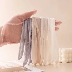 Primo piano che mostra i vari colori e la trama a rete traspirante dei guanti in seta