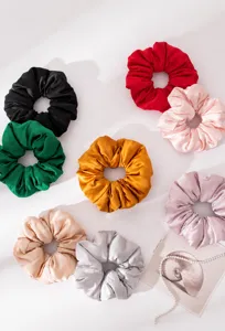 Close-up view of premium silk satin scrunchies in multiple elegant solid colors