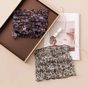 Detail view of floral print silk neck gaiter with mesh texture for sun protection
