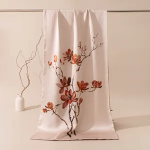 Gros plan sur l'élégant imprimé de magnolia aquarelle sur un châle en satin de soie