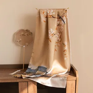 Detailed view of champagne silk scarf with magnolia and traditional architecture print
