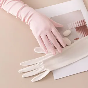 Close-up of elegant long mulberry silk gloves in soft pink and white silk colors