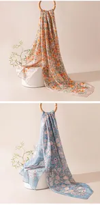 Détail rapproché de foulards d'été à fleurs légers et doux en motifs bleus et oranges