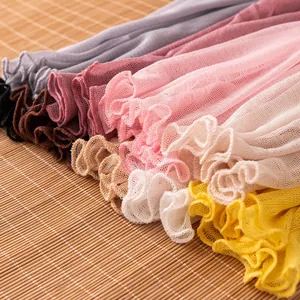 Detailed view of silk mesh neck gaiters featuring ruffled edges in various vibrant colors