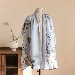 Detail view of a luxury blue satin shawl with traditional Chinese bird and floral embroidery