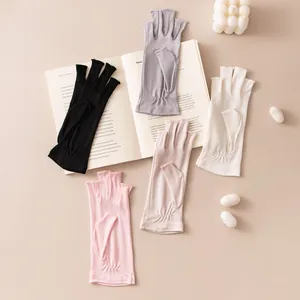 Disposición de guantes de seda de medio dedo en rosa, beige, negro, gris y blanco de seda.