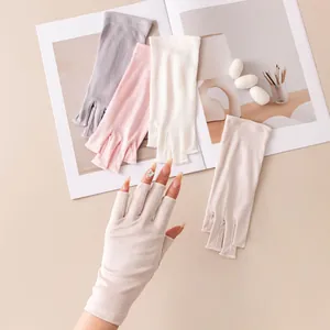 Detalle de guantes de seda de medio dedo para protección solar en colores pastel suaves