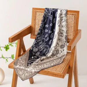 Détail d'un foulard en soie à motif paisley sur une chaise en rotin