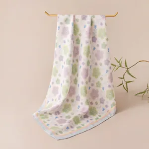 Detail shot of a floral print silk scarf hanging on a gold rack, soft pastel colors.