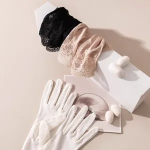 Vue détaillée de gants élégants en dentelle vintage en noir, couleur chair et blanc