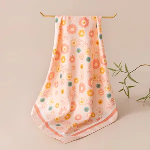 Close-up of elegant pink silk square scarf with floral pattern and Yes Girl text