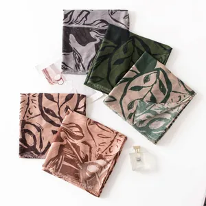 Flat lay of vintage leaf print silk scarves in earthy colors with decorative props
