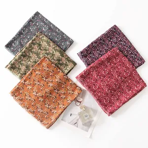 Detailed view of various colorful retro floral scarves with frayed edges on white background.