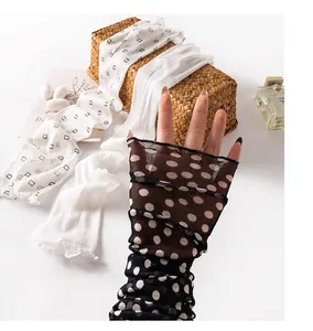 Close-up of polka dot silk mesh sun protection arm sleeves with fingerless design.
