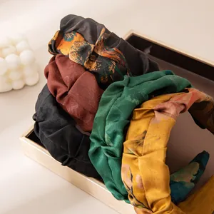 Detail of vintage silk satin headbands with floral jacquard patterns in a display box.