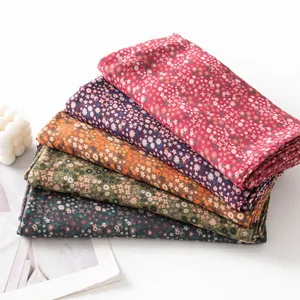 Stack of vintage floral scarves in various colors showing fabric texture and patterns