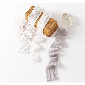 Elegant detail view of silk sun protection sleeves with mesh texture and ruffles