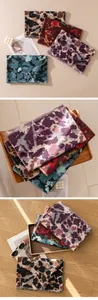 Detailed view of vintage long scarves featuring colorful abstract ink-wash prints and fringe edges.