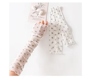 Detail of breathable mesh sun protection sleeves with geometric pattern and ruffles