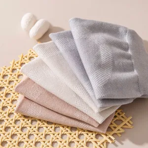 Nahaufnahme von weichen, dünnen Kniebandagen aus Seide in neutralen Pastellfarben