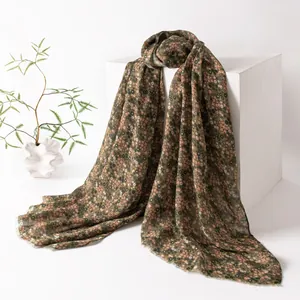Detailed view of a vintage floral print scarf featuring delicate green and peach ditsy patterns.