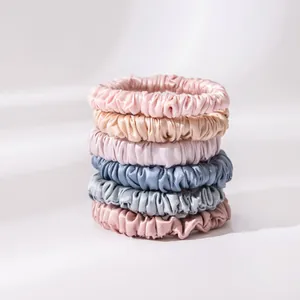 Detailed view of silk scrunchies stack showing smooth texture and pastel colors