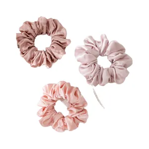 Set of three large silk scrunchies in elegant satin shades of pink and nude for hair styling